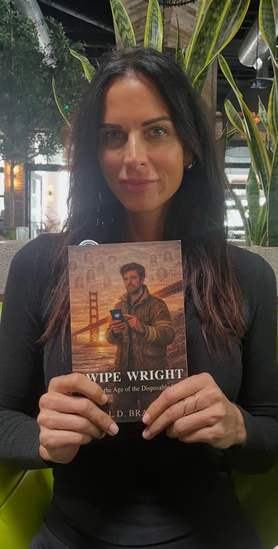 Ana Christian holding a paperback copy of Swipe Wright: Dating in the Age of the Disposable Heart by Joel D. Bradley